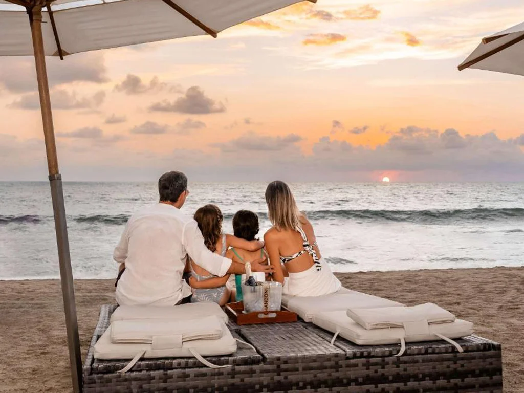 Familia observando un atardecer en las playas de puerto vallarta.
