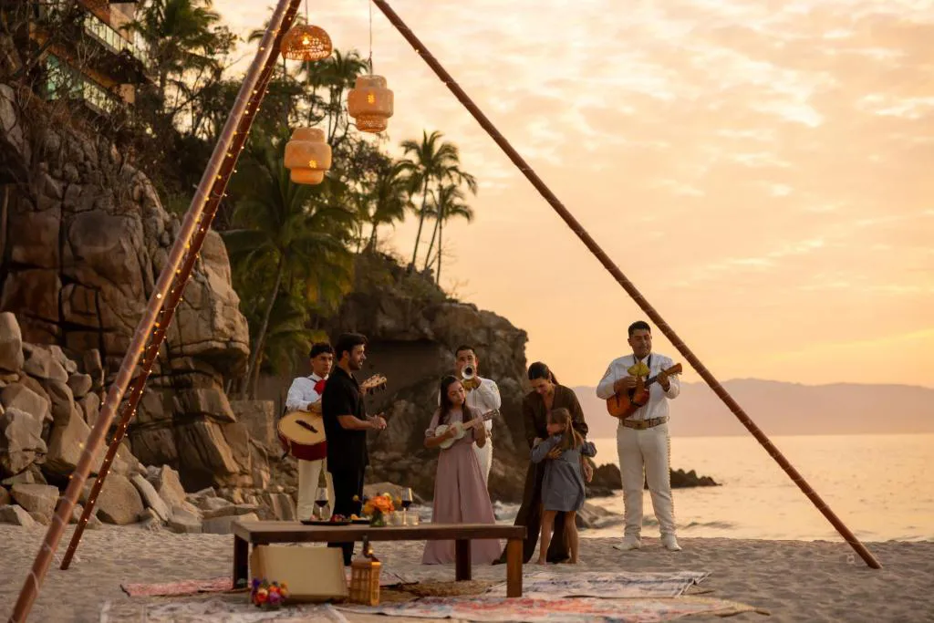 familia en puerto vallarta recibiendo una serenata con mariachis en un atardecer.